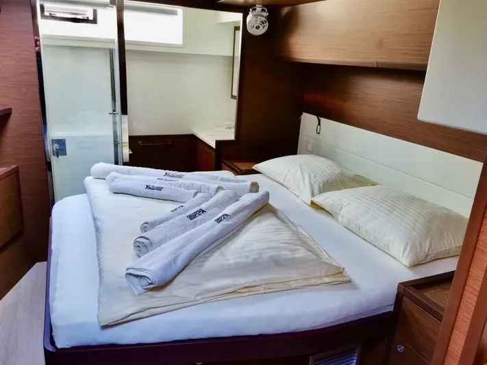 Tiga Yacht Photos Pics Luxurious cabin interior of 2020 Lagoon 52 F yacht with neatly arranged bed and towels.