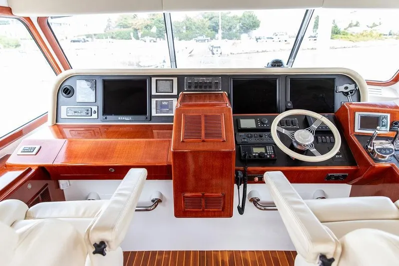 Marina Yacht Photos Pics Helm of 2008 Huckins Linwood yacht with wooden dashboard and modern navigation equipment.