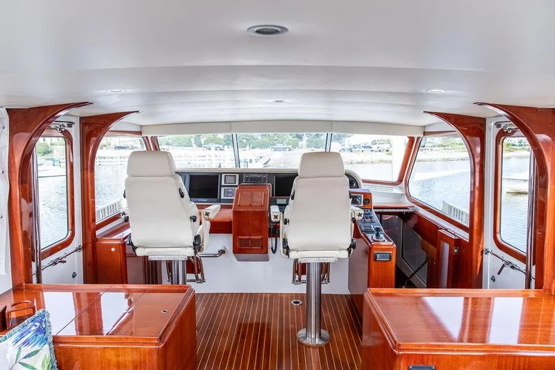 Marina Yacht Photos Pics Interior of a 2008 Huckins Linwood yacht with elegant wood finish and dual captain chairs.