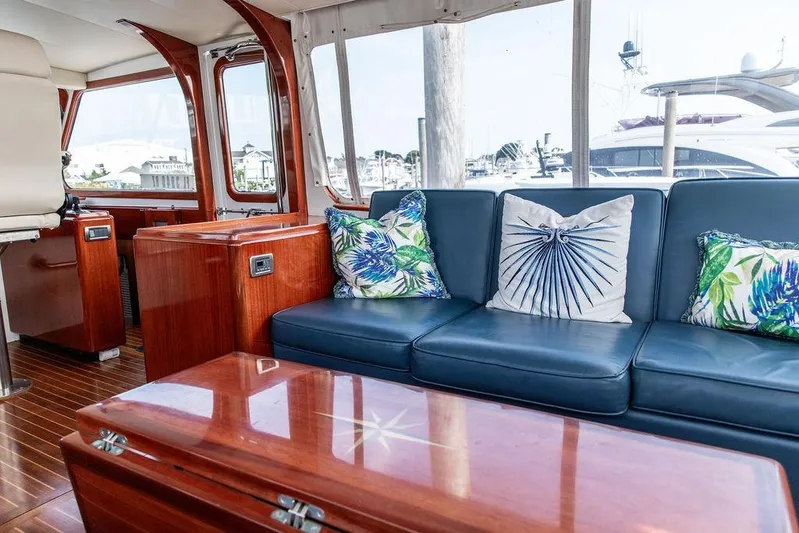 Marina Yacht Photos Pics Luxurious 2008 Huckins Linwood yacht interior with blue leather seating and tropical-themed cushions.