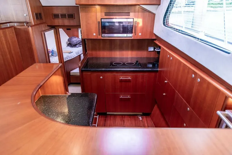 Marina Yacht Photos Pics Luxurious 2008 Huckins Linwood yacht kitchen with wood cabinetry and modern appliances.