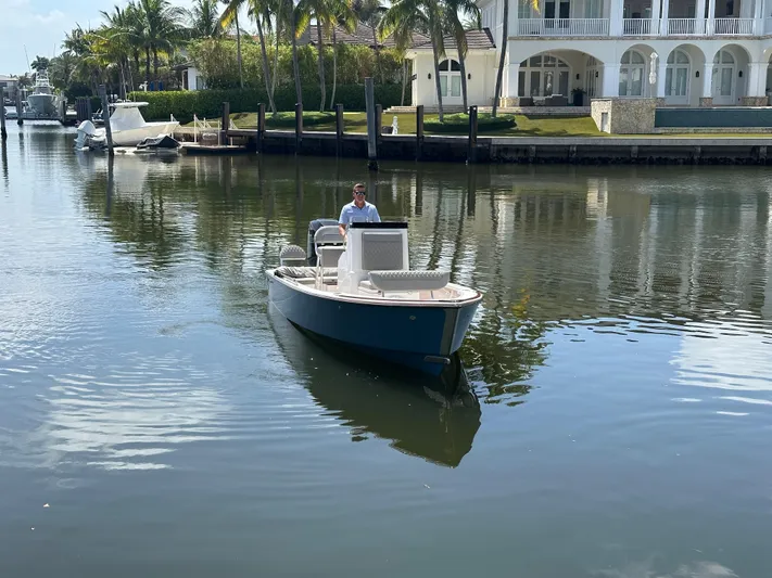  Yacht Photos Pics 2024 Dragonfly 21 Spanish Wells boat on calm water near luxury waterfront homes.