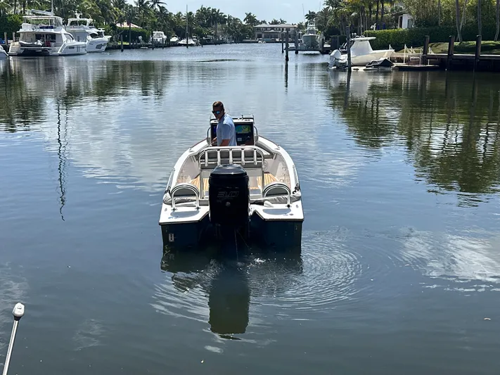  Yacht Photos Pics 2024 Dragonfly 21 Spanish Wells boat navigating a calm waterway with palm trees.