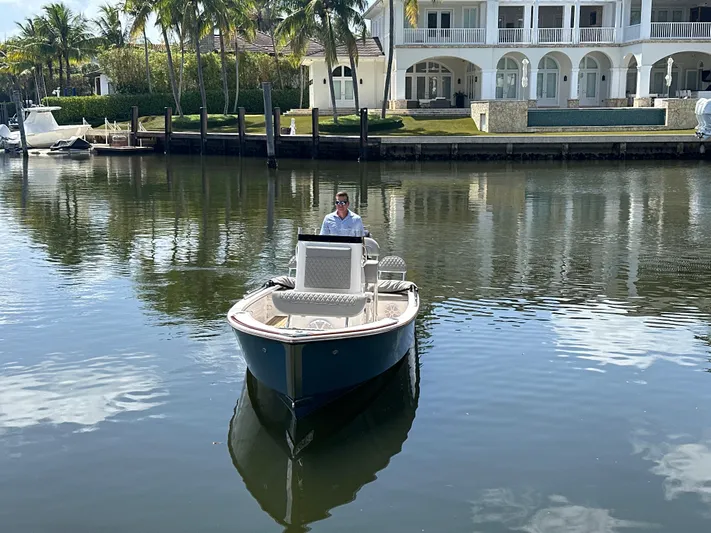  Yacht Photos Pics 2024 Dragonfly 21 Spanish Wells boat on calm water near luxury waterfront home.