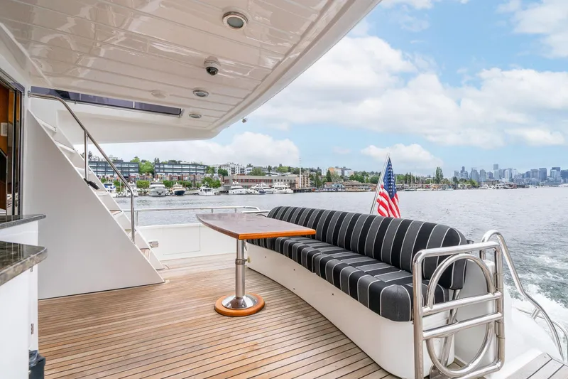 Royal Viking Yacht Photos Pics Luxurious 1999 Vitech 68' Pilothouse yacht deck with seating, table, and scenic waterfront view.