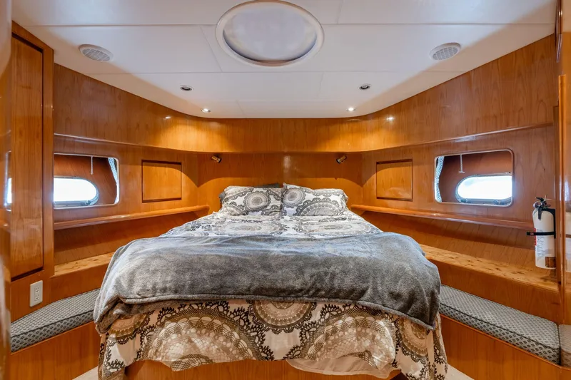 Royal Viking Yacht Photos Pics Luxurious bedroom interior of 1999 Vitech 68' Pilothouse yacht with wood paneling and cozy bedding.