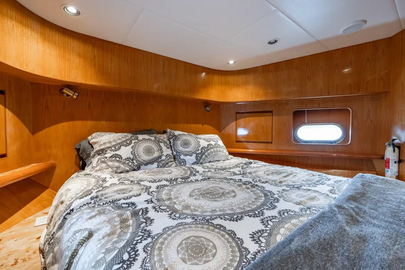 Royal Viking Yacht Photos Pics Luxurious bedroom in 1999 Vitech 68' Pilothouse yacht with elegant bedding and wood paneling.