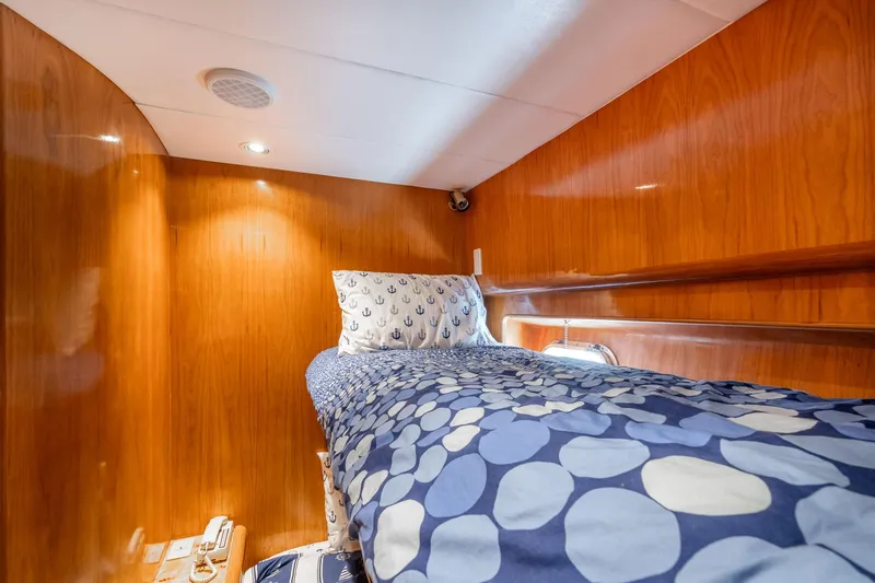 Royal Viking Yacht Photos Pics Cozy cabin interior of 1999 Vitech 68' Pilothouse yacht with wooden paneling and patterned bedding.