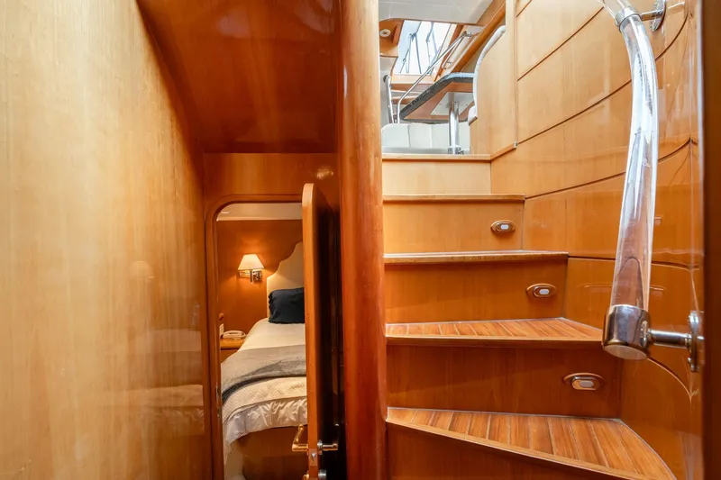 Royal Viking Yacht Photos Pics Interior of 1999 Vitech 68' Pilothouse yacht with wooden stairs and cozy bedroom.