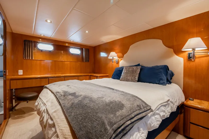 Royal Viking Yacht Photos Pics Luxurious bedroom in 1999 Vitech 68' Pilothouse yacht with elegant wood paneling and cozy bedding.