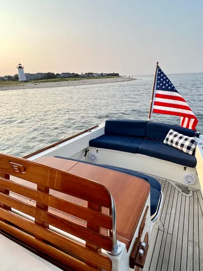 Wayfarer Yacht Photos Pics 2002 Hinckley Talaria 29C boat with American flag, wooden deck, and coastal lighthouse view.