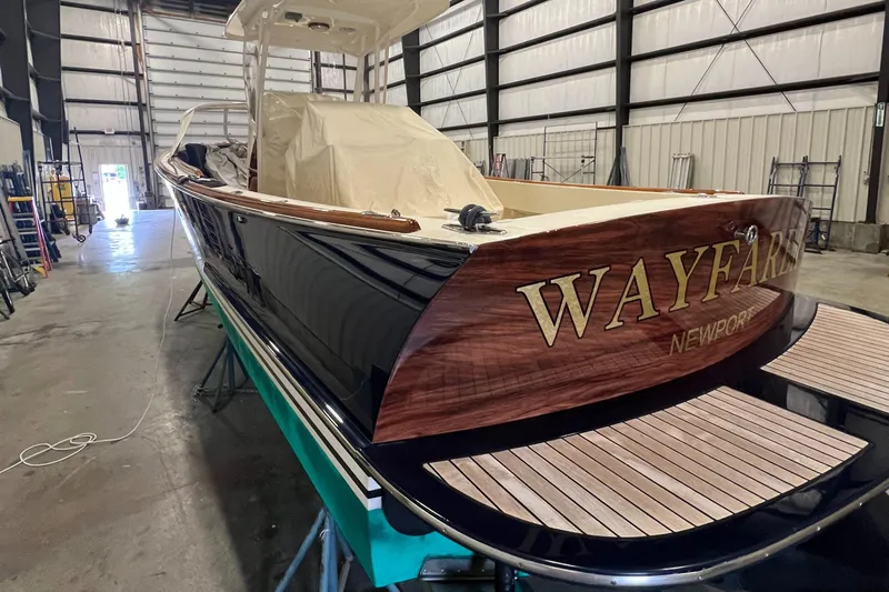 Wayfarer Yacht Photos Pics 2002 Hinckley Talaria 29C boat in warehouse, featuring "Wayfarer" name on wooden stern.