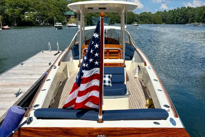 Wayfarer Yacht Photos Pics 2002 Hinckley Talaria 29C boat with American flag, docked on a serene lake.