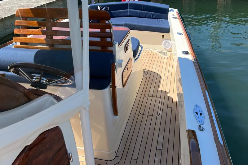 Wayfarer Yacht Photos Pics 2002 Hinckley Talaria 29C boat with teak deck and blue seating, docked on calm water.