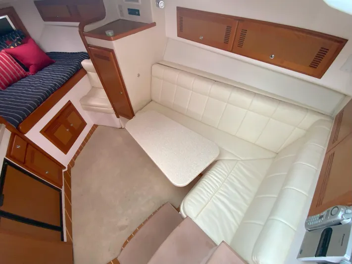 Arbutus Yacht Photos Pics 2006 Cabo 32 Express HT interior with white leather seating and compact dining area.