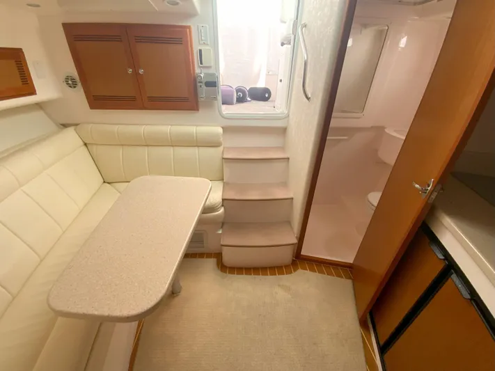 Arbutus Yacht Photos Pics Interior of 2006 Cabo 32 Express HT yacht with seating, table, and compact kitchen area.