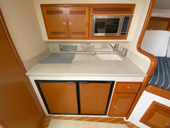 Arbutus Yacht Photos Pics 2006 Cabo 32 Express HT galley with microwave, sink, and storage cabinets.
