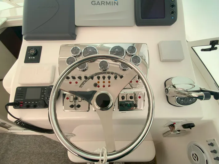 Arbutus Yacht Photos Pics Control panel of a 2006 Cabo 32 Express HT boat with steering wheel and navigation instruments.