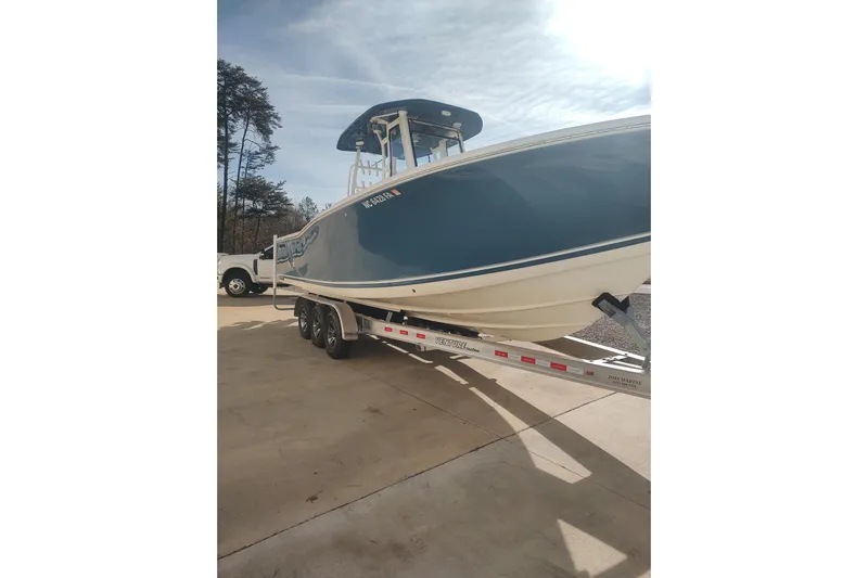  Yacht Photos Pics 2023 Tidewater 292 CC Adventure boat on trailer, parked outdoors.