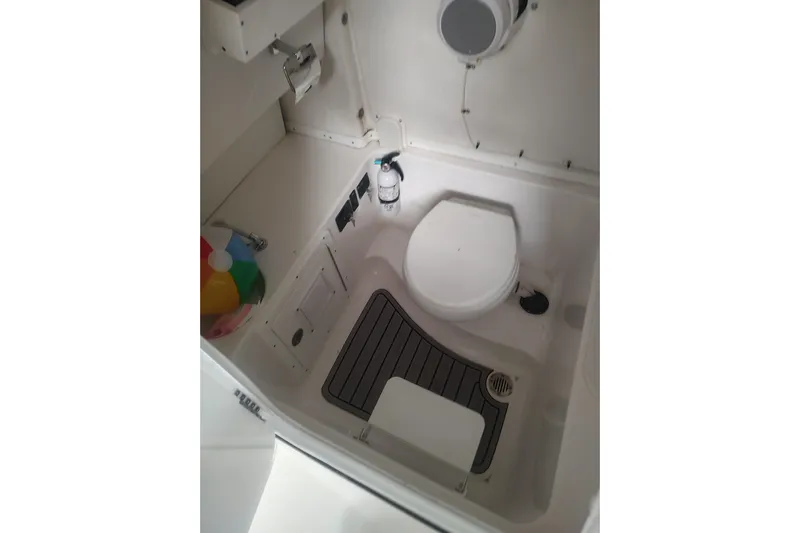  Yacht Photos Pics 2023 Tidewater 292 CC Adventure boat bathroom interior with toilet and storage.