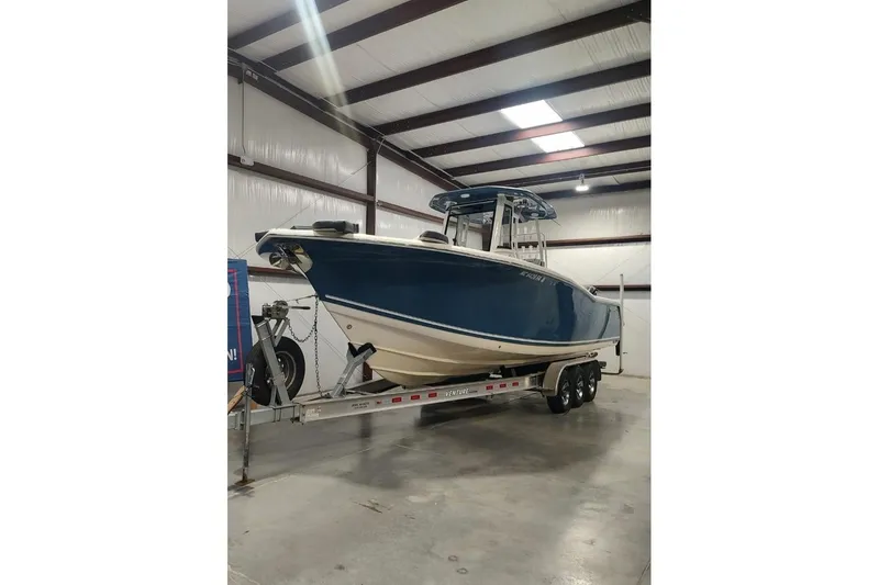  Yacht Photos Pics 2023 Tidewater 292 CC Adventure boat on trailer in indoor storage facility.
