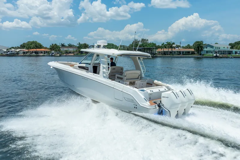  Yacht Photos Pics 2021 Boston Whaler 350 Realm cruising on a sunny day, showcasing sleek design and powerful engines.