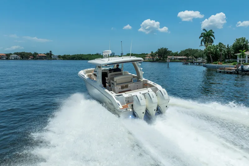  Yacht Photos Pics 2021 Boston Whaler 350 Realm cruising on a sunny day, showcasing powerful engines and sleek design.
