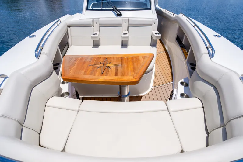  Yacht Photos Pics Boston Whaler 350 Realm 2021 boat interior with cushioned seating and wooden table.