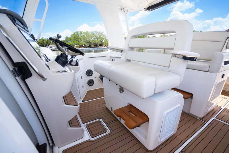  Yacht Photos Pics 2021 Boston Whaler 350 Realm interior with white seating and wooden flooring.