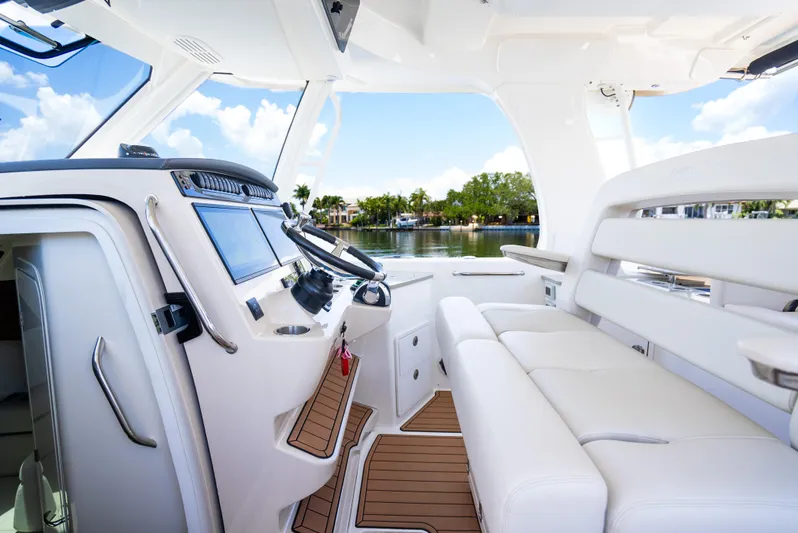  Yacht Photos Pics 2021 Boston Whaler 350 Realm interior with modern helm and seating, overlooking serene water.