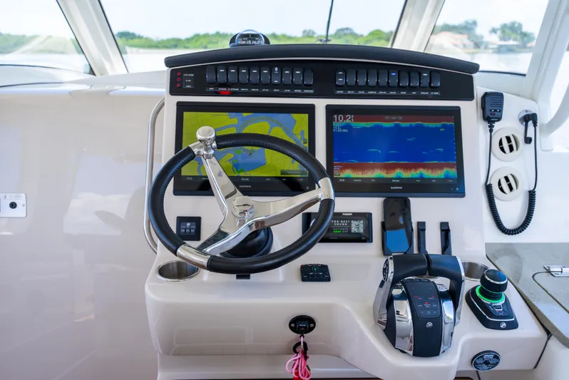  Yacht Photos Pics Control panel of 2021 Boston Whaler 350 Realm with navigation screens and steering wheel.