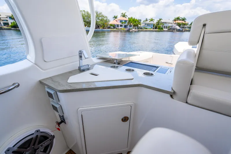  Yacht Photos Pics 2021 Boston Whaler 350 Realm interior with sleek countertop and seating, overlooking serene waterfront.