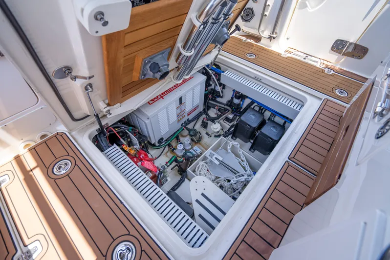  Yacht Photos Pics 2021 Boston Whaler 350 Realm engine compartment with batteries and equipment, featuring teak flooring.