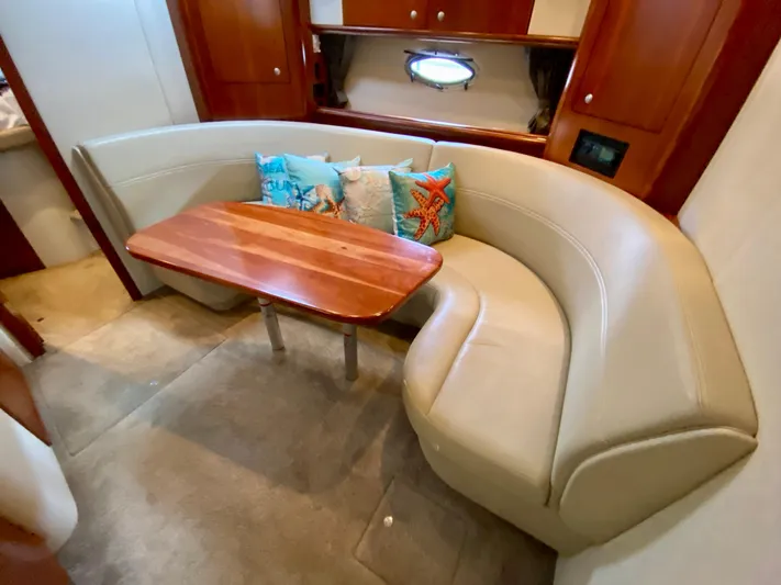  Yacht Photos Pics 2007 Cruisers Yachts 370 Express interior with curved seating and wooden table.