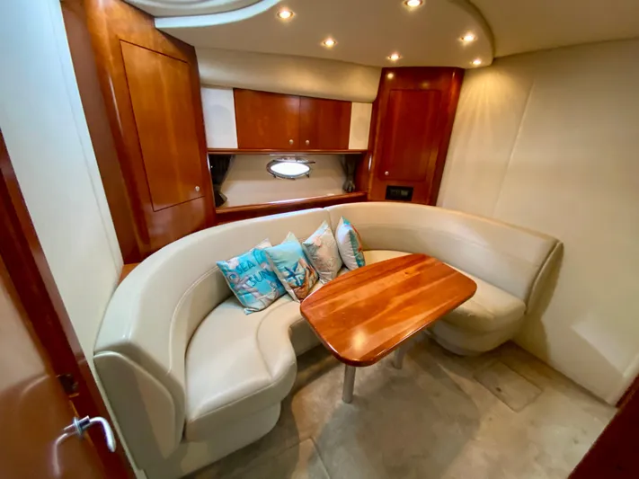  Yacht Photos Pics 2007 Cruisers Yachts 370 Express interior with curved seating and wooden table.