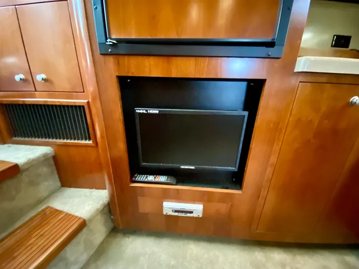  Yacht Photos Pics 2007 Cruisers Yachts 370 Express interior with built-in TV and wooden cabinetry.