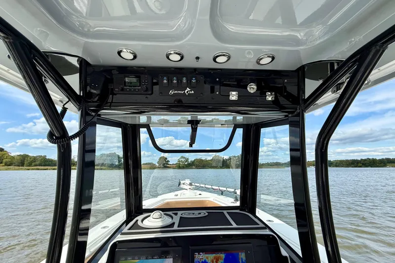  Yacht Photos Pics 2021 Sea Hunt Gamefish 27 Coffin Box boat interior with navigation equipment on a calm lake.