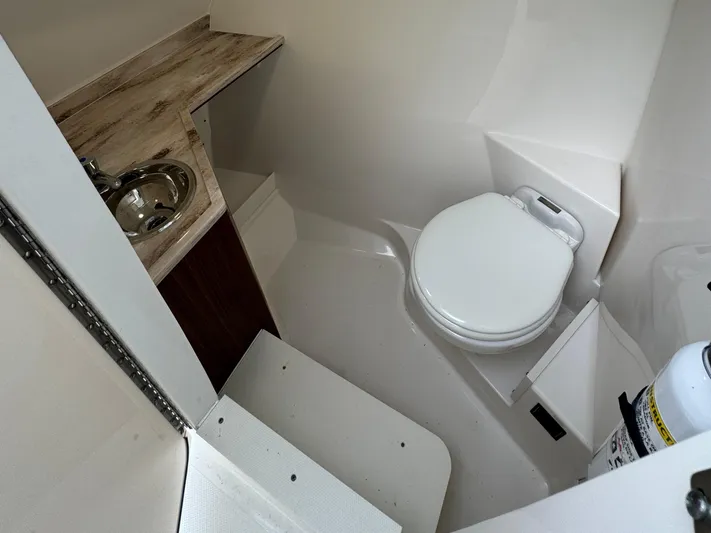  Yacht Photos Pics 2024 Pursuit DC 295 Dual Console boat bathroom with sink and toilet.