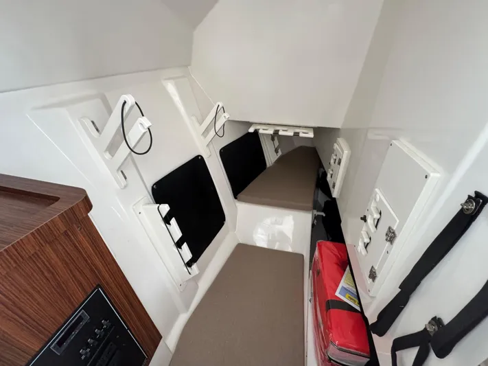  Yacht Photos Pics 2024 Pursuit DC 295 Dual Console cabin interior with seating and storage compartments.