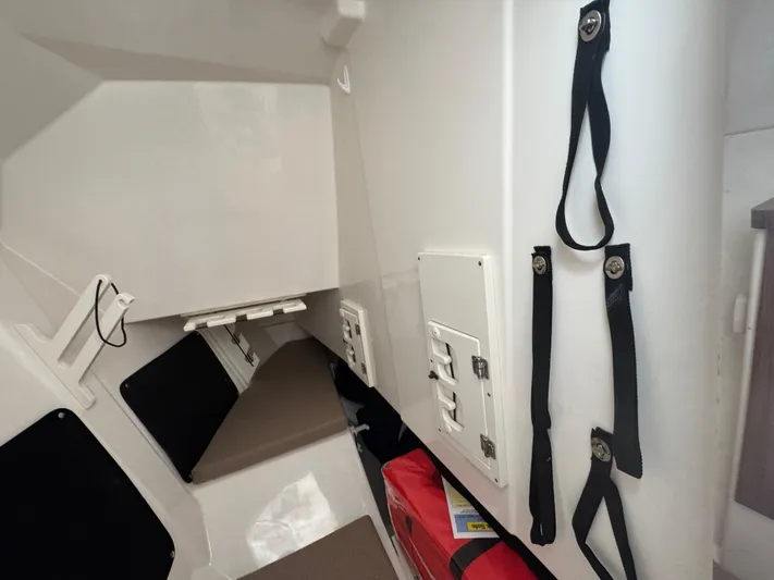  Yacht Photos Pics 2024 Pursuit DC 295 Dual Console interior cabin with seating and storage straps.