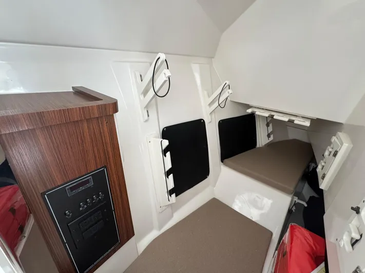  Yacht Photos Pics 2024 Pursuit DC 295 Dual Console cabin interior with seating and control panel.