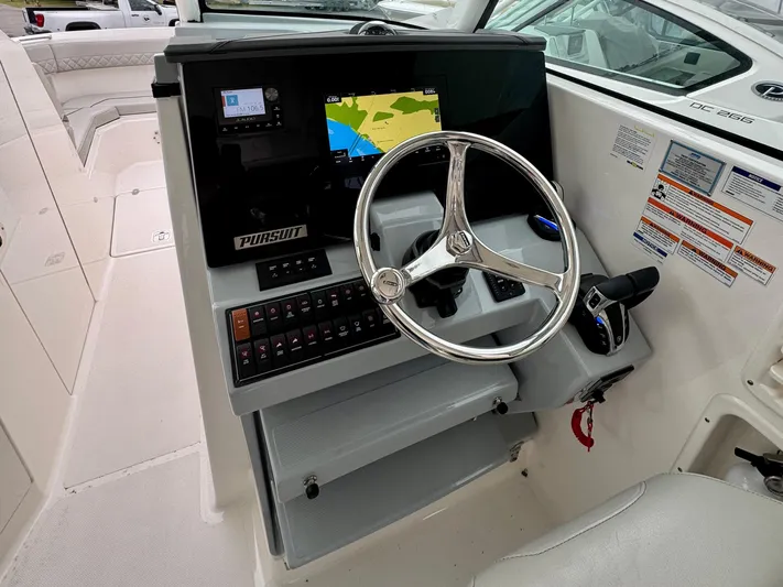  Yacht Photos Pics 2024 Pursuit DC 295 Dual Console boat helm with steering wheel and navigation display.