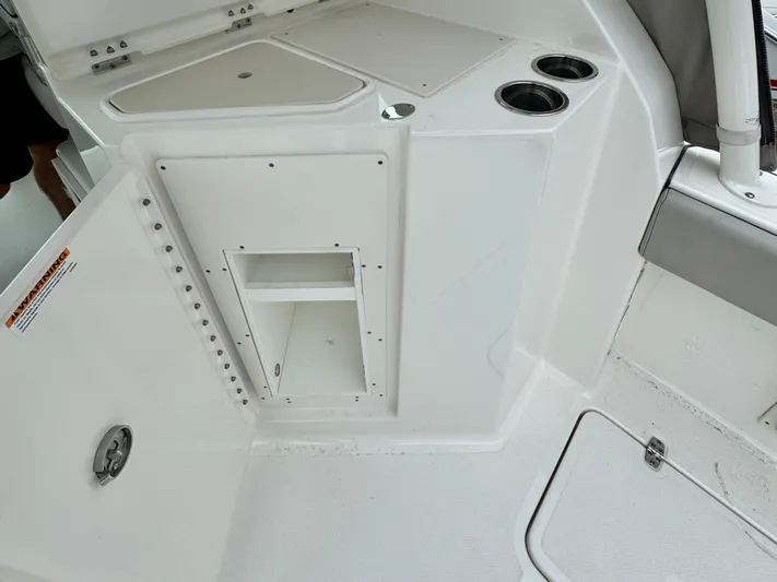  Yacht Photos Pics 2024 Pursuit DC 295 Dual Console interior with storage compartment and cup holders.