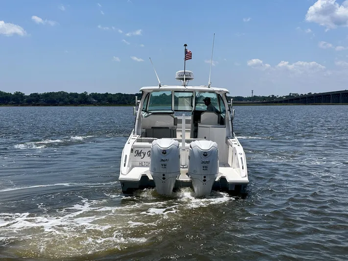  Yacht Photos Pics 2024 Pursuit DC 295 Dual Console boat cruising on a sunny day.