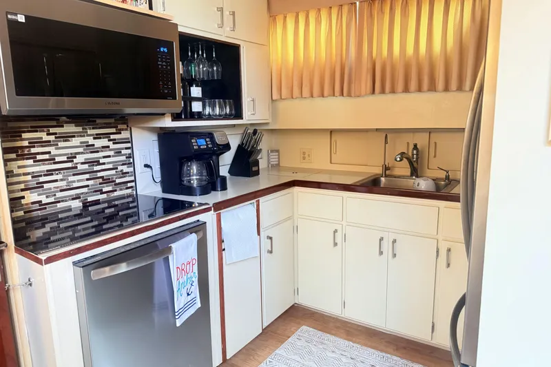 Lady Malan Yacht Photos Pics Modern kitchen in 1987 Hatteras 54 Motor Yacht with stainless appliances and mosaic backsplash.