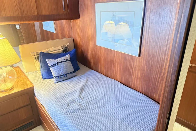 Lady Malan Yacht Photos Pics Cozy cabin interior of 1987 Hatteras 54 Motor Yacht with blue bedding and wooden paneling.