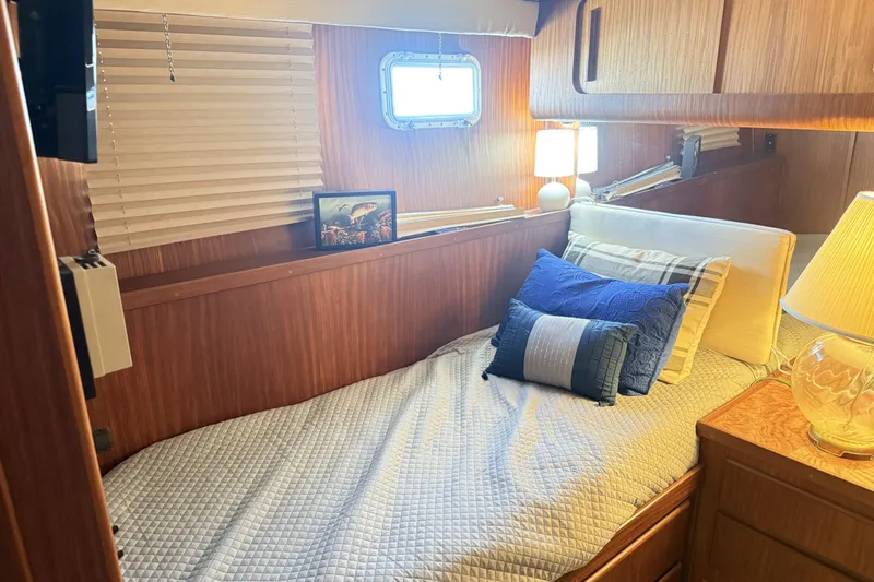 Lady Malan Yacht Photos Pics Cozy cabin interior of 1987 Hatteras 54 Motor Yacht with bed and decorative pillows.