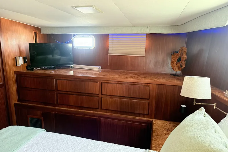 Lady Malan Yacht Photos Pics Interior of 1987 Hatteras 54 Motor Yacht with TV, wooden cabinetry, and lamp.