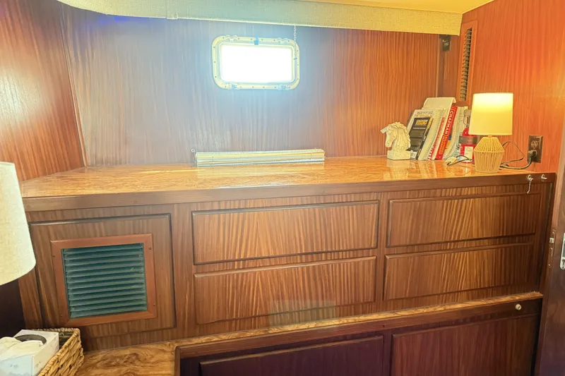 Lady Malan Yacht Photos Pics 1987 Hatteras 54 Motor Yacht interior with wooden cabinetry and books.