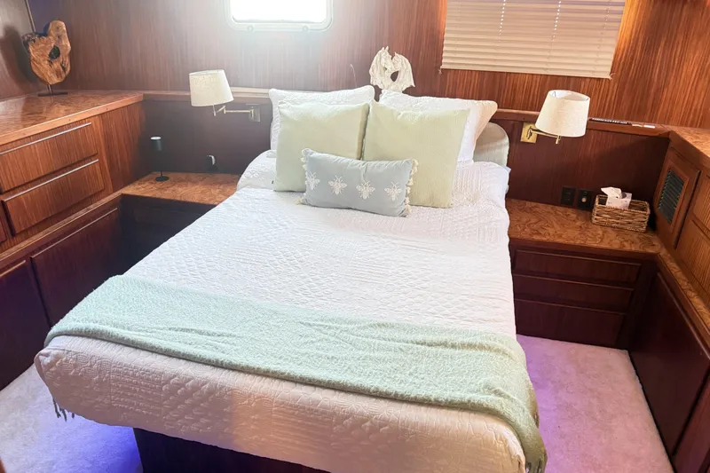 Lady Malan Yacht Photos Pics Cozy bedroom interior of 1987 Hatteras 54 Motor Yacht with elegant wood finish.